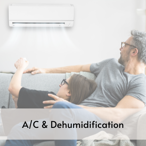 Man and woman laying together on couch glancing over appreciatively at an air conditioner on the wall